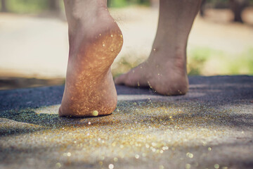 Feet walking with a shower of glitter.