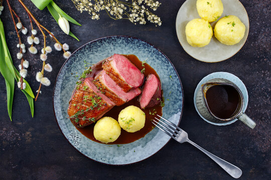 Traditionell gegrilltes Gourmet Entenbrust Filet mit Haut serviert mit Kartoffelkn&ouml;deln in Dunkelbier Sauce als Draufsicht auf einem Design Teller