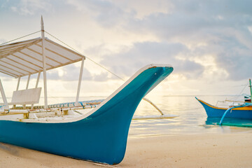Beautiful colorful sunrise on the seashore with fishing boats. Philippines, Siargao Island.