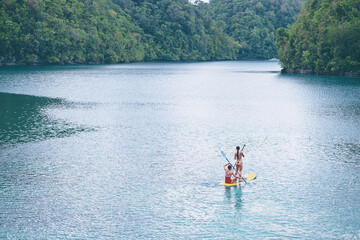 Summer holidays vacation travel. SUP Stand up paddle board. Young women sailing together on beautiful calm lagoon.