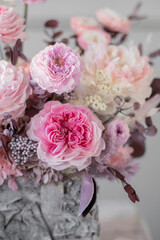 Flowers arrangement with roses in bark pot in vintage.