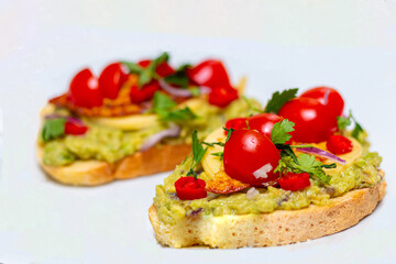 Healthy open vegan sandwich with avocado mash, zucchini, cherry tomatoes, cheese on top of corn bread. Healthy food, vegetarian food concept