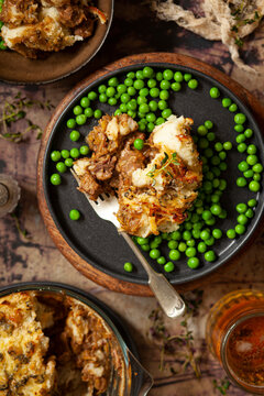 A Portion Of Steak And Stilton Cheese Pie Served With Peas.