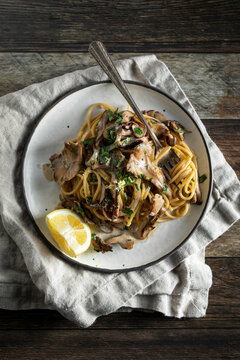 Creamy Pasta with Crispy Mushrooms on a Wooden Background