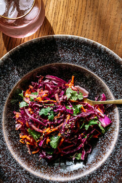 A large red cabbage salad plate, glass, view from above, on wooden background