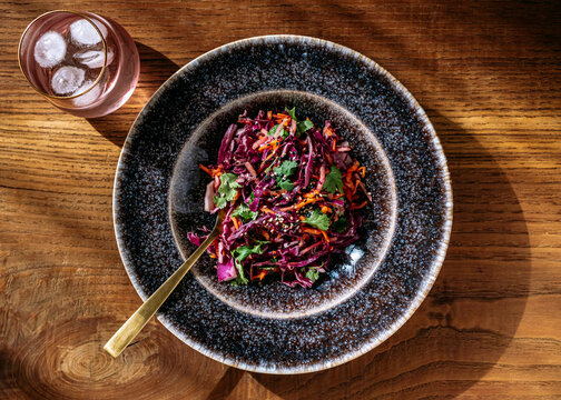 A large red cabbage salad plate, glass, view from above, on wooden background