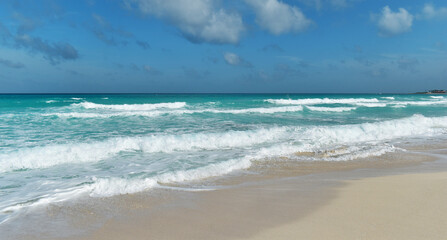 Fototapeta na wymiar Sandy shore, beach and turquoise sea, big waves, Caribbean, Cancun, Yucatan, Mexico.