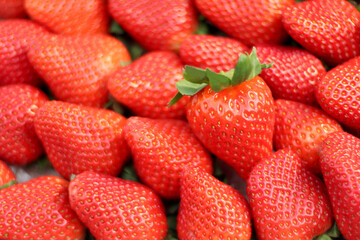 Strawberry, background Large grain and sweet. This strawberry is produced in Huelva, Spain. Just one showing the green crown