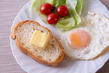 トーストや卵を調理した物をお皿に盛り付けた朝食のイメージ