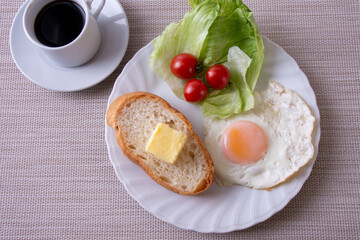 トーストや卵を調理した物をお皿に盛り付けた朝食のイメージ