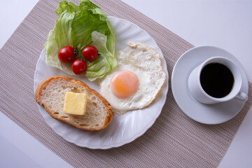 トーストや卵を調理した物をお皿に盛り付けた朝食のイメージ