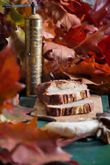 Banana pie on a background of autumn bright leaves, a copper coffee grinder 
