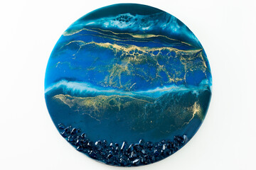 Resin art composition with blue colors and stones on white