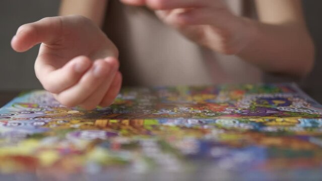 Child hands on board game. A girl hands move figure on the board game on the table.
