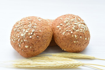 Round wholemeal oat bread, sweetened with natural panela, displayed on white wood