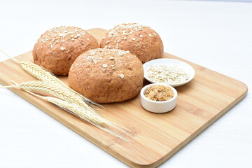 Round wholemeal oat bread, sweetened with natural panela, displayed on white wood