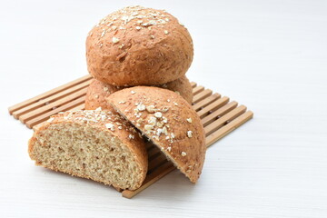 Round wholemeal oat bread, sweetened with natural panela, displayed on white wood