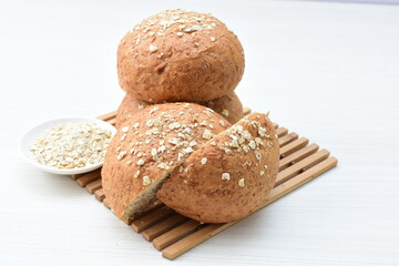 Round wholemeal oat bread, sweetened with natural panela, displayed on white wood