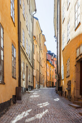 Bright sun reflections on narrow street in historic part of Stockholm. Old fashioned building in Gamla stan, old part of town. Sweden.