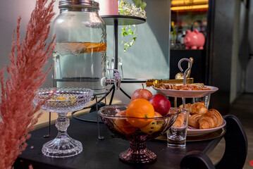Food and cold beverage arranged on table in luxurious hotel room