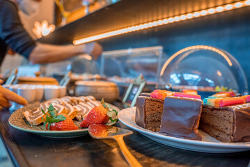 Assortment of fresh sweet cake slices in plate on counter at restaurant