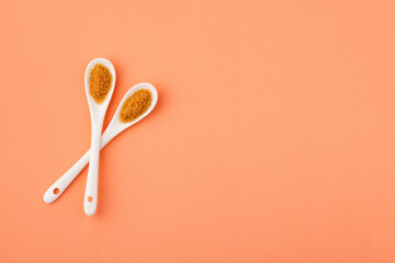 Saccharum officinarum - Organic brown sugar in two ceramic spoons