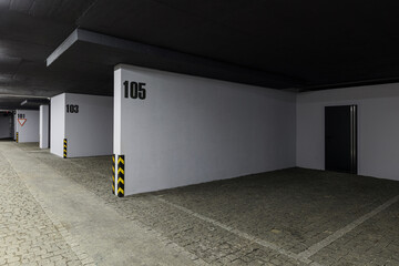 Large parking lot with garage numbers for residents in a multi-storey building.