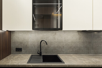 Sink in the studio kitchen. Trendy furniture in the living room and modern details in the kitchen...