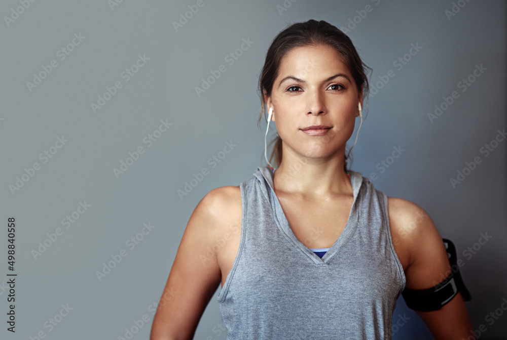 Sticker Determined to reach her fitness goals. Studio portrait of a sporty young woman standing against a gray background.