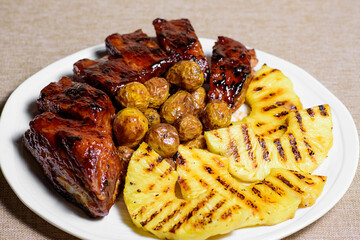 Exotic barbecue meat with spicy chili sauce and pineapple chunks