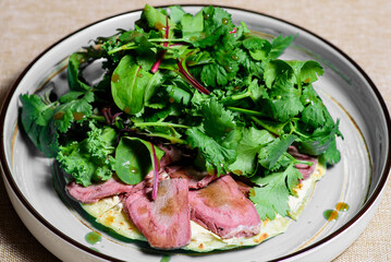 Grilled beef steak with green salad on a gray rustic plate. Medium barbecue steak and healthy salad