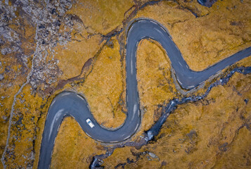 Aerial view on serpentine road on the island Streymoy near the village Nordradalur with view of Koltur island. Faroe Islands, Denmark. November 2021. Lonely wanderer on serpentine road