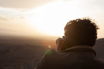 photographer photographs the sunset on the mountains