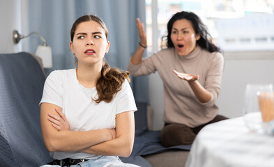 Woman comforting her friend after a domestic quarrel while sitting on the couch