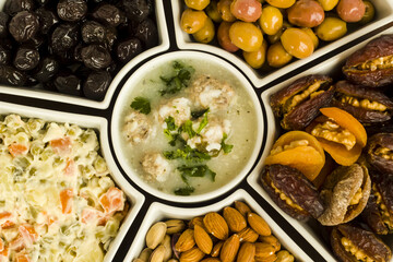 Traditional Ramadan iftar,beginning menu set background with soup,olives,date fruit,nuts and salad.Top view