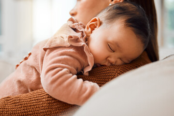 This little one loves nap time. Shot of an adorable baby girl sleeping on her mothers arms.