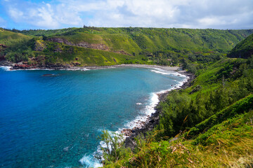 Fototapeta na wymiar Honokohau Bay between the Kahekili and Honoapiilani highways on West Maui, Hawaii - Lush valley ending on a gravel beach in the Pacific Ocean