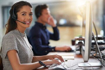 Shes all about attending to customers needs. Shot of young agents working in a call center.