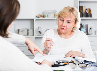Financial adviser helps a mature woman deal with her bills