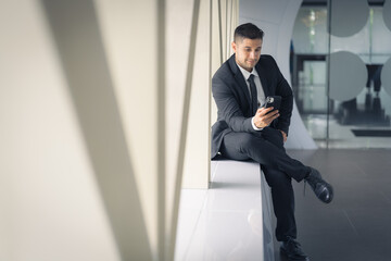 Business portrait of caucasian businessman holding smartphone on hand
