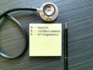 HRA concept written on sticky note with a pen and stethoscope.