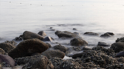 Obraz premium Waves crashing against rocks - water flowing over rocks