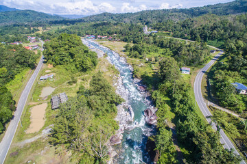 aerial view of mountain river flowing across tropical hills and boulders in Kota Belud Sabah Malaysian Borneo.