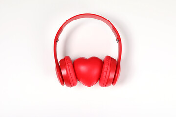 red headphones with red heart sign in the middle on white surface.