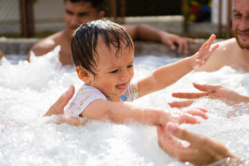 latino baby learning to swim in a bubble pool with help, matroswimming aquatic stimulation activity