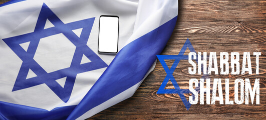 Flag of Israel, mobile phone and text SHABBAT SHALOM on wooden background - obrazy, fototapety, plakaty