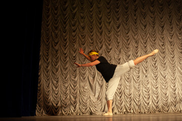 Ballerina jumps. Jump in dance. Dance teacher shows movement. Dance lesson on stage.