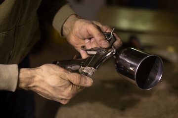 Naklejka premium Guy is holding airbrush. Man with painted remote in his hand.