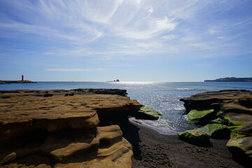 mossy rocks beach and charming clouds