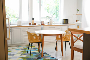 Dining table with chairs in modern interior of kitchen